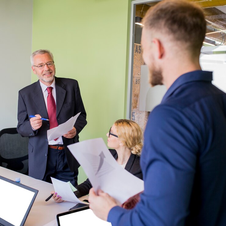 smiling mature businessman having discussion with graph 23 2147923302